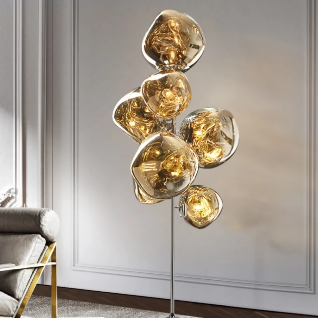 Nordic Lava LED Floor Lamp with a sleek gold electroplated finish, featuring multiple reflective bubble-like LED bulbs emitting a warm ambient glow in a modern minimalist living room