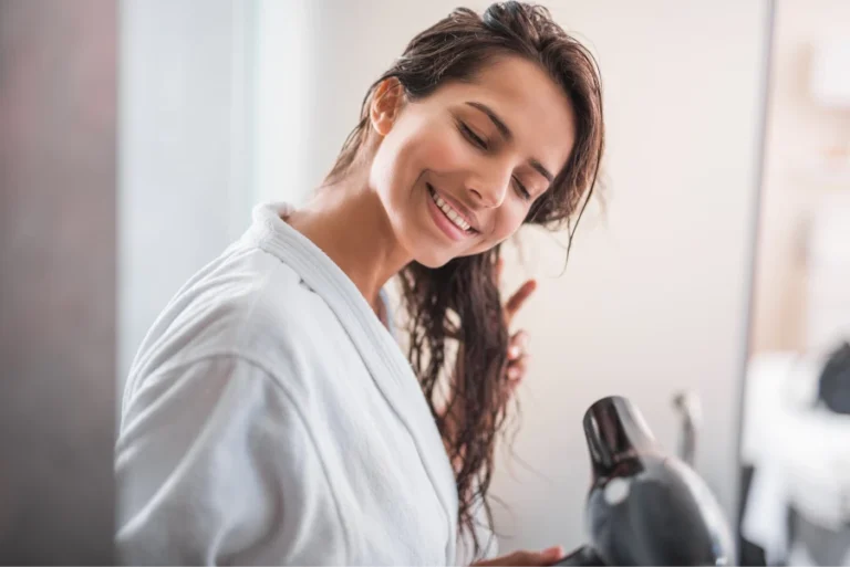 Woman using ionic hair dryer with diffuser for curls