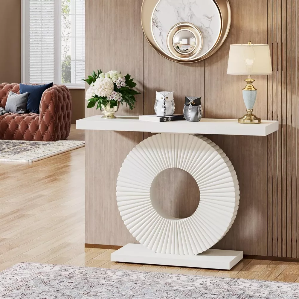 Elegant modern white entryway console table with circular sculptural base, styled with a lamp, decorative owls, and flowers in a contemporary foyer.